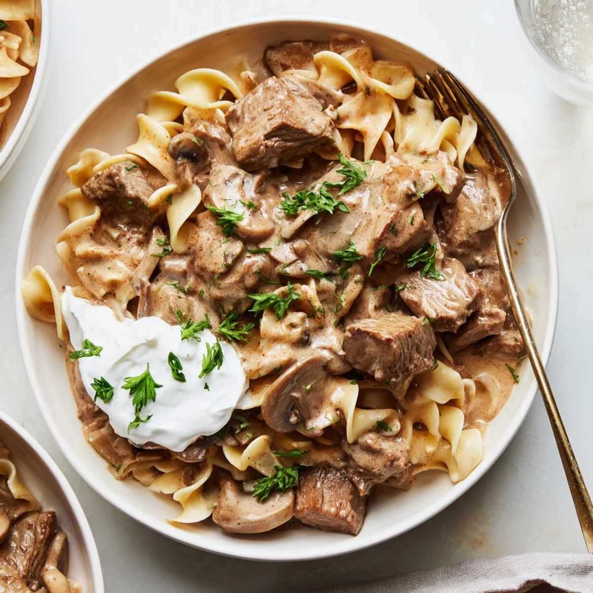 Tender beef and mushrooms in Slow Cooker Beef Stroganoff with fresh parsley topping.  