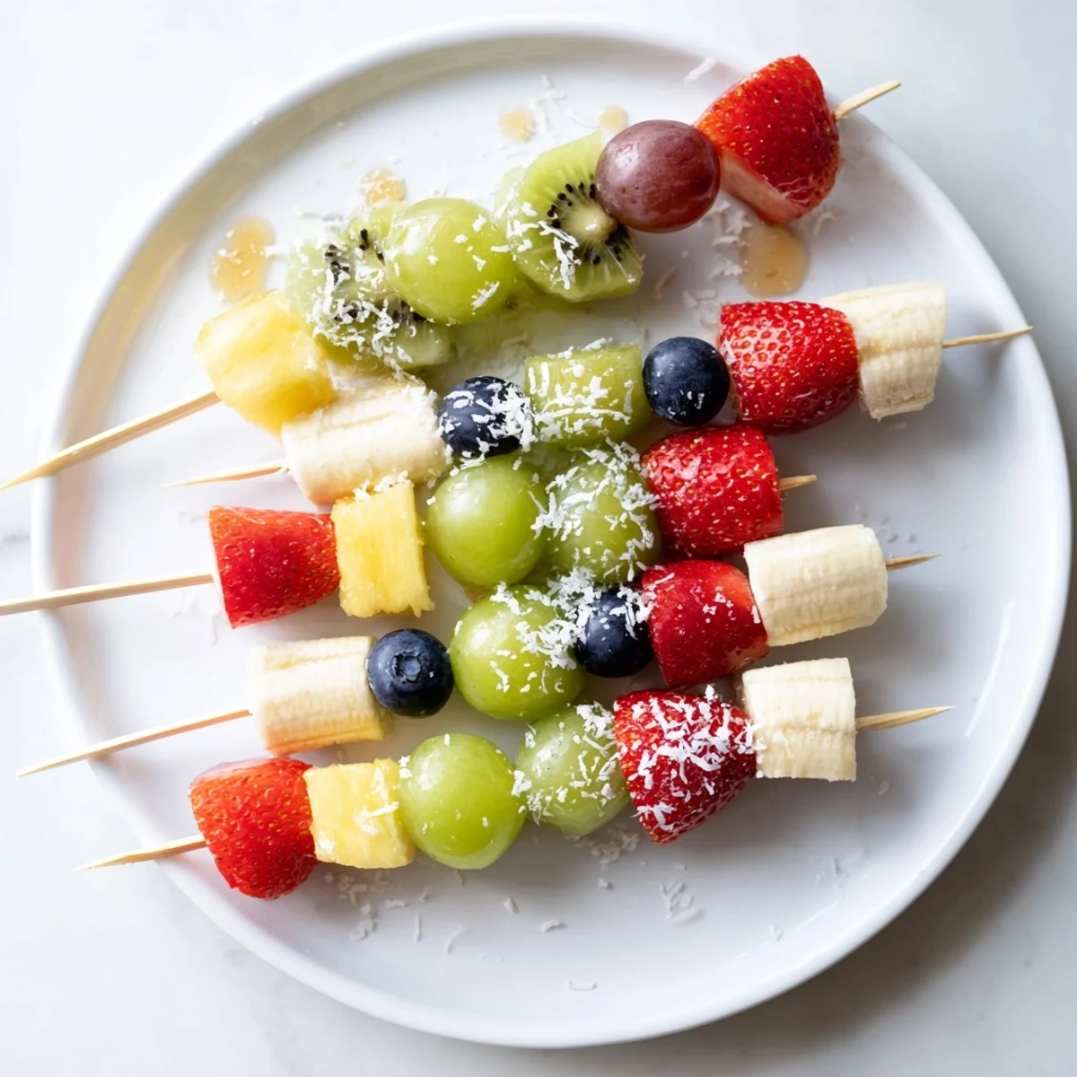 Sweet and juicy festive fruit kabobs ready to eat, featuring strawberries, grapes, and pineapple chunks.