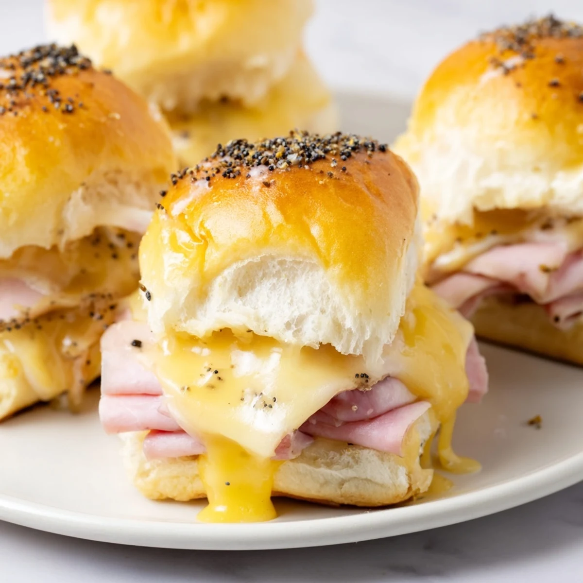 Golden-brown Budget-Friendly Ham & Cheese Sliders, oozing melted cheese, perfect for a quick and easy dinner.