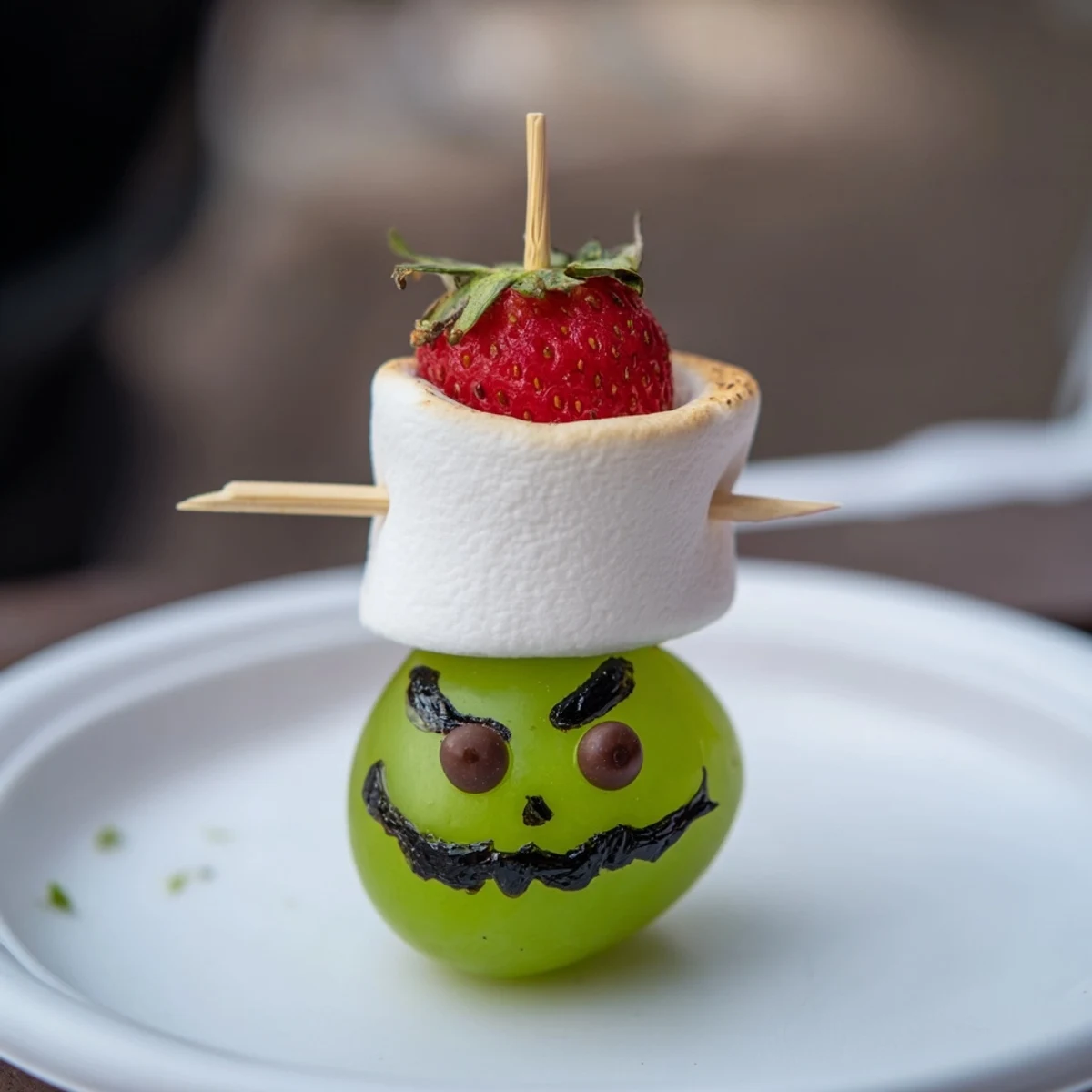 Kid-friendly Grinch Snack: a delightful assembly of green grapes and frosted grinning faces.