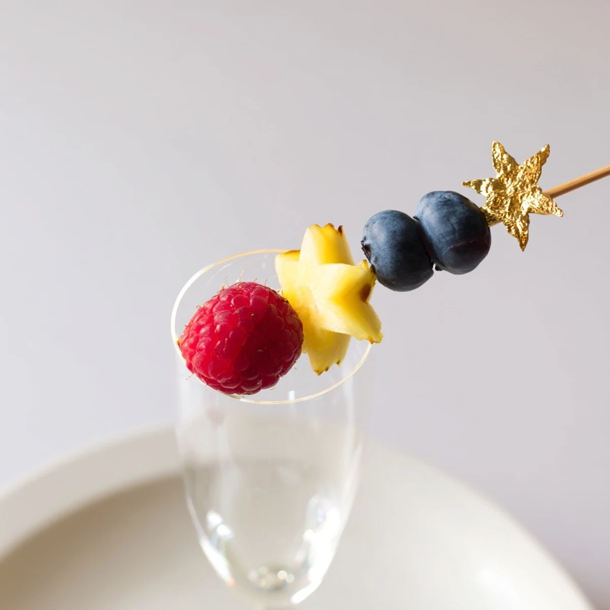 Vibrant champagne flute fruit garnishes featuring strawberries, pineapple, and kiwi offer a colorful treat.