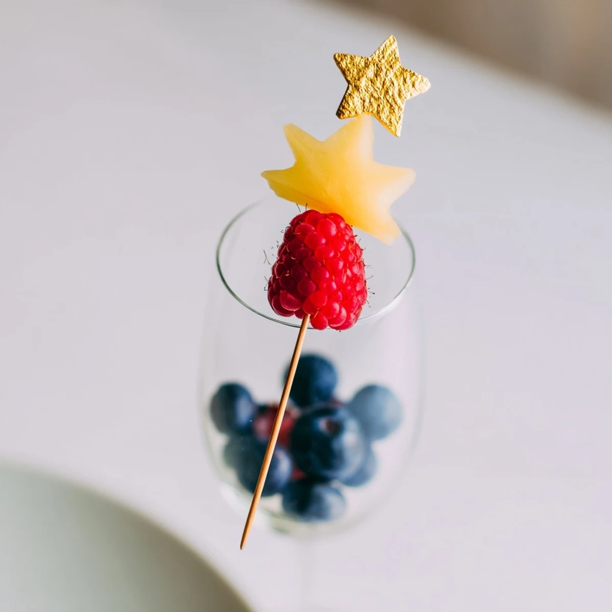 Enjoy a close-up of champagne flute fruit garnishes, ready to enhance the New Year's eve bubbly experience and adding fresh flavors.
