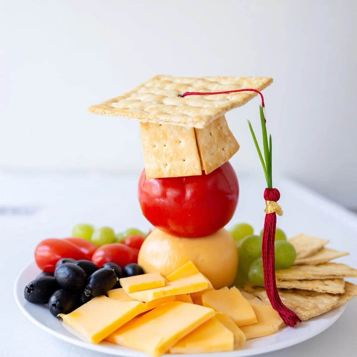 A delicious Graduation Cap Platter with cheddar cheese, grapes, and olives ready to serve at a party.