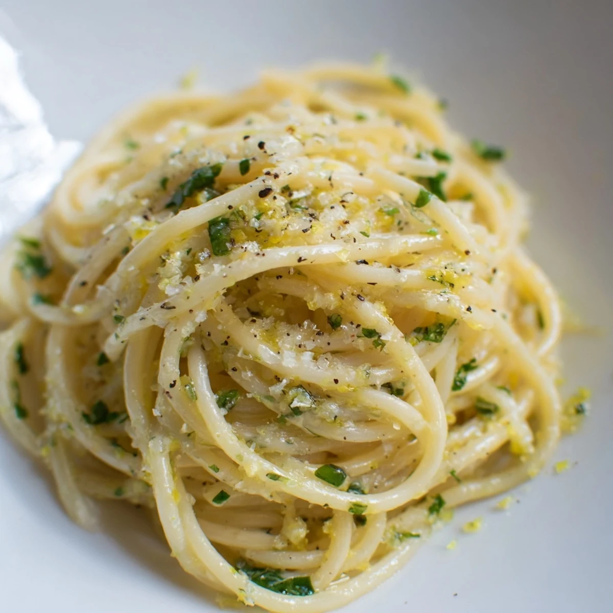 A close-up view of Lemon Capellini, perfectly coated in lemon butter sauce, ready to eat.