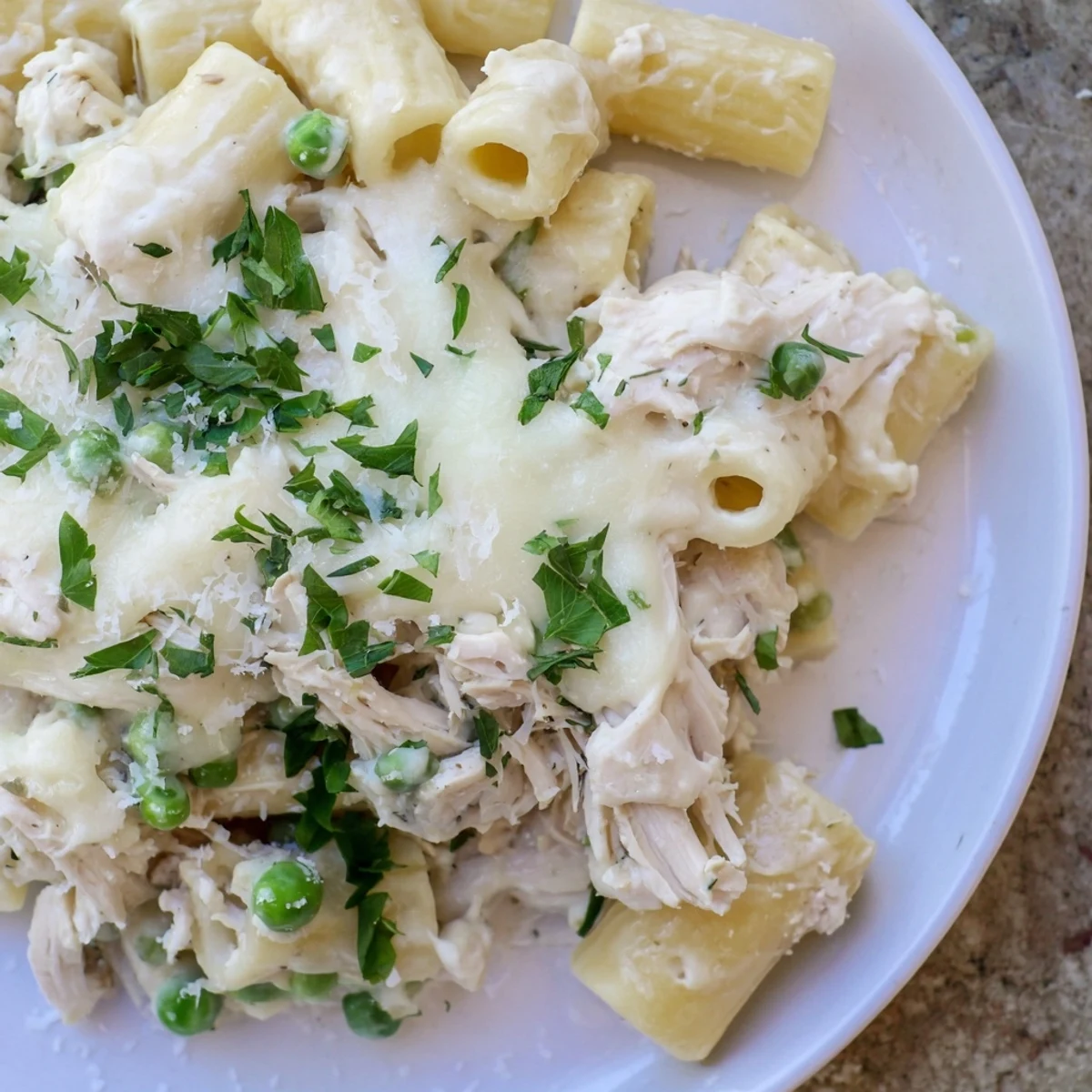 Slow cooker chicken Alfredo pasta bake, perfect for a cozy dinner, is creamy and bubbling hot.