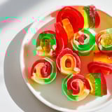 These Rainbow Candy Roll Ups showcase bright fruit roll-ups wrapped around chewy gummy candies.