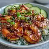 A close-up view of a vibrant Asian Shrimp Bowl, featuring juicy grilled shrimp, edamame, and julienned vegetables in a savory sauce.