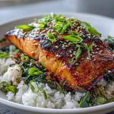 A close-up of a Japanese-inspired miso glazed salmon bowl featuring tender fish, vibrant spinach, and fragrant rice for a balanced dinner.
