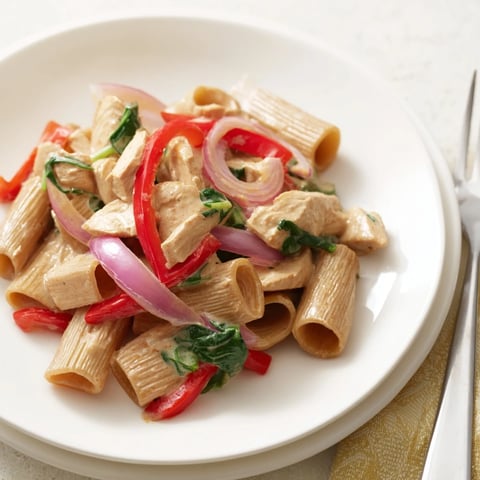 Creamy Cajun Dirty Snow Chicken Pasta, steaming in a bowl, with vibrant peppers and tender chicken pieces.