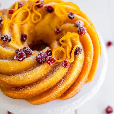 A close-up of The Cranberry Orange Swirl cake unveils a tangy, vibrant cranberry and orange spiral.