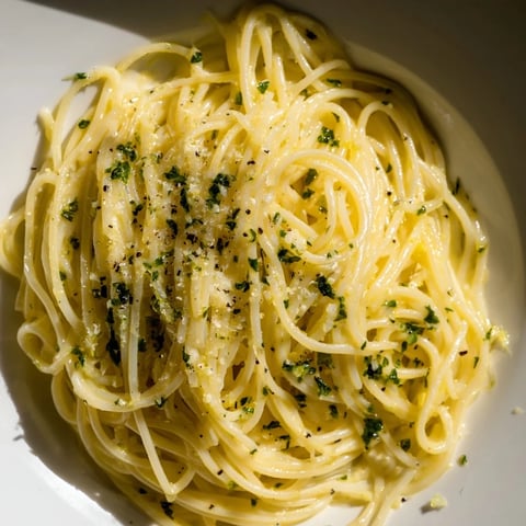Bright, creamy Lemon Capellini with fresh herbs, ready to be tossed and served on a plate.