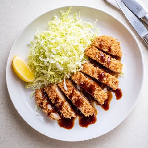 Golden-brown Chicken Katsu cutlets with crispy panko crumbs, served over steamed rice and drizzled with tangy tonkatsu sauce.