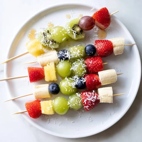 Sweet and juicy festive fruit kabobs ready to eat, featuring strawberries, grapes, and pineapple chunks.