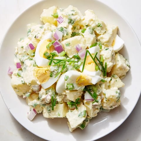 This hearty bowl of chopped egg and potato salad includes tender potatoes, fresh herbs, and a tangy mayonnaise dressing.
