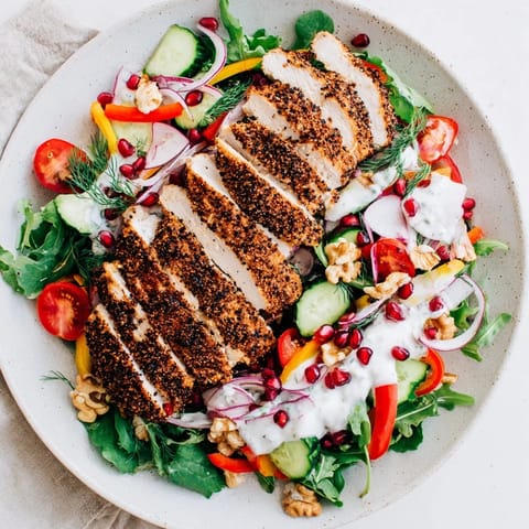 Holiday Black Pepper Chicken salad, showcasing tender chicken over fresh greens with creamy yogurt dressing.