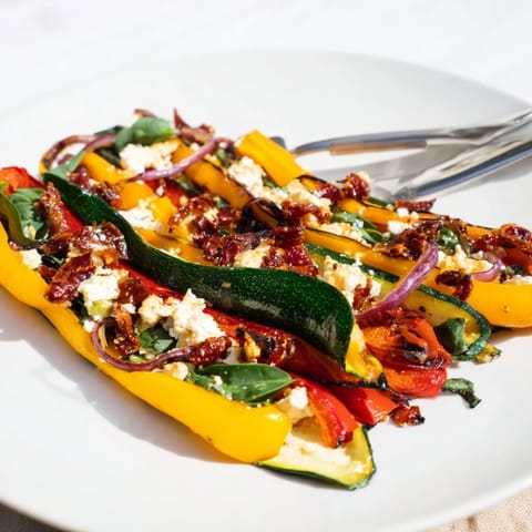 Colorful Roasted Veggie & Feta Santa Spiral Wraps arranged as festive appetizers on a white platter.