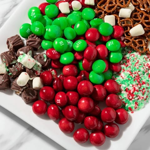 Festive Santa's Sack Candy Avalanche arrangement featuring chocolate, cookies, and other holiday treats, perfect for sharing.