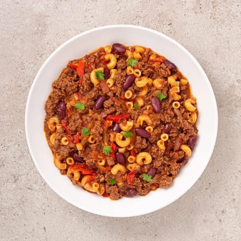 Close-up of a bubbling pot of ditalini with hot cocoa chili, the pasta and chili blending.