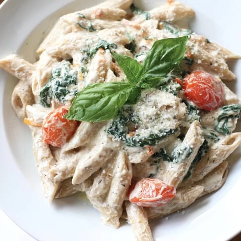 A bowl of delicious Cottage Cheese High-Protein Creamy Pasta, freshly garnished with basil and Parmesan.