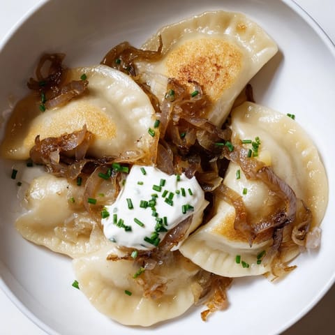A close-up of savory Polish pierogi, filled with potato and cheese, ready to be served.