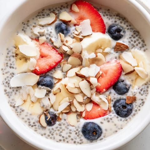Creamy chia seed pudding layered with fresh berries and sliced almonds in a glass jar.  