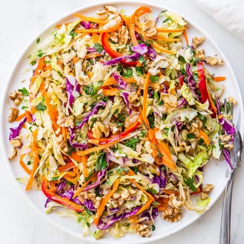 Golden-hued sautéed cabbage tossed with julienned carrots, red onion, and a tangy apple cider vinegar dressing for this Cooked and Loved Cabbage Salad.