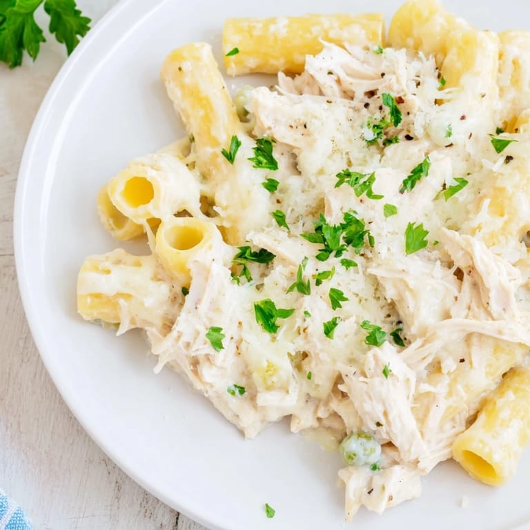 Savory slow cooker chicken Alfredo pasta bake featuring tender chicken and rich, cheesy sauce.