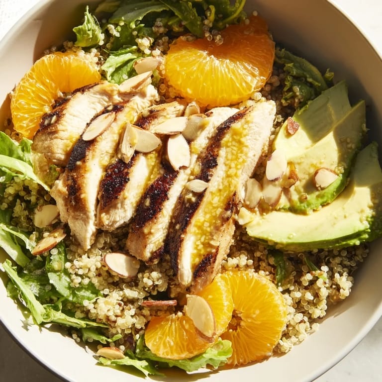 Bright orange segments and sliced avocado accompany herb-marinated grilled chicken in this colorful Citrus Herb Chicken Salad Bowl.