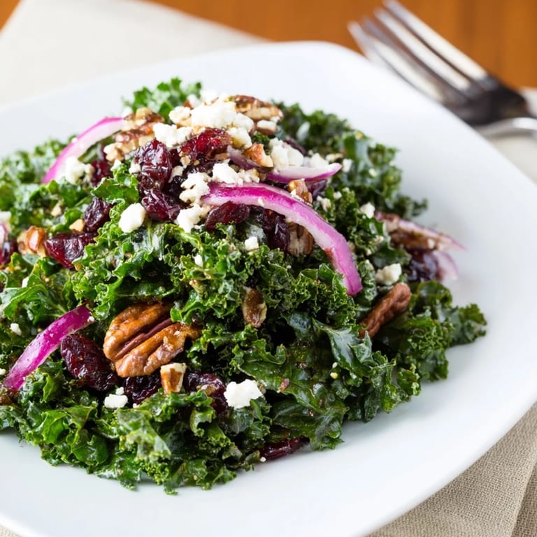 Hearty bowl of warm kale salad with maple mustard dressing, tossed with toasted walnuts, cranberries, and a light, tangy glaze—perfect for a healthy vegetarian lunch.