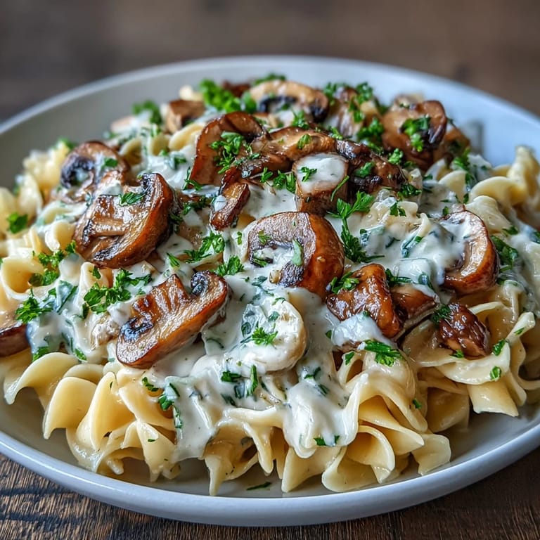 Overhead view of Creamy Mushroom Stroganoff on fettuccine noodles, showcasing the rich, velvety sauce.
