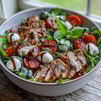 Vibrant Caprese Chicken Bowl featuring juicy grilled chicken, creamy mozzarella, ripe tomatoes, and fresh basil leaves.